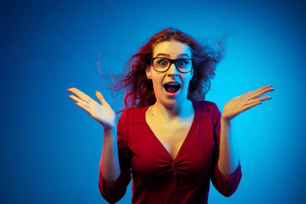 istock Caucasian woman's portrait isolated on blue studio background in neon light 1194887023