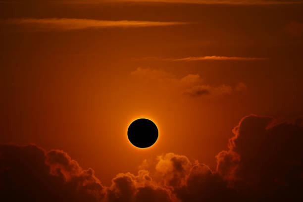 istock phenomenon of partial sun eclipse over silhouette orange cloud and sunset sky 1194887048