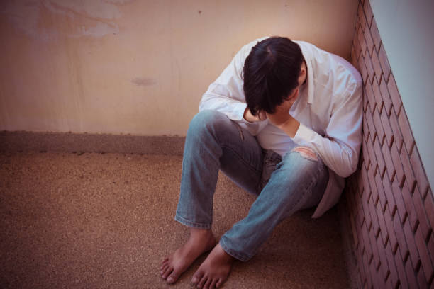 istock Depressed man sitting head in hands in building. with low light environment, dramatic concept, concept of Major depressive disorder, unemployed, sadness, depressed and human problems, 1194888432