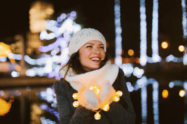 istock Young woman holding Christmas lights 1194888756