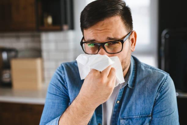istock Young man with cold , flu, running nose at home 1194888856