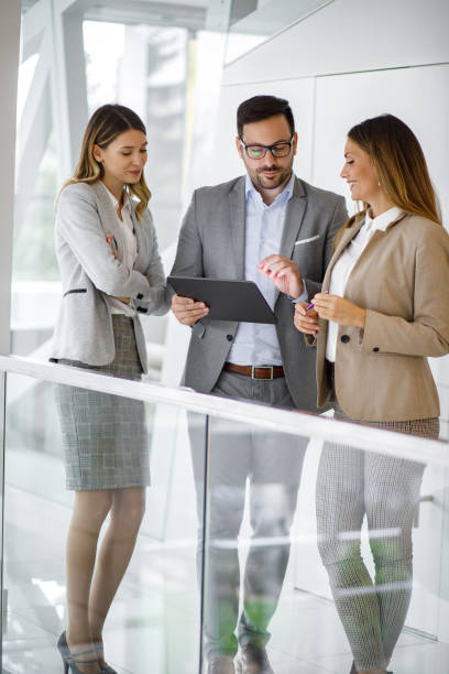 istock Young business people discussing ideas over digital tablet in office lobby 1194890157