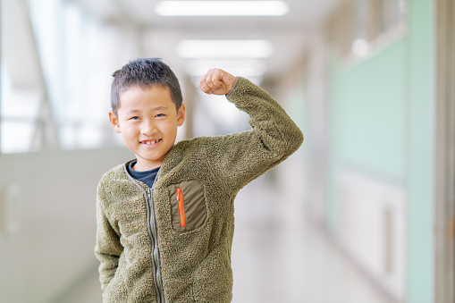A portrait of a happy elementary school schoolboy in hallways.