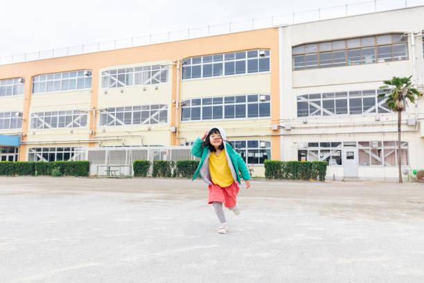 pequeña y linda colegiala primaria corriendo en el patio de la escuela - child running playing tag fotografías e imágenes de stock