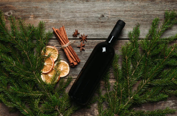 Christmas background with wine bottle and pine branches on the rustic background
