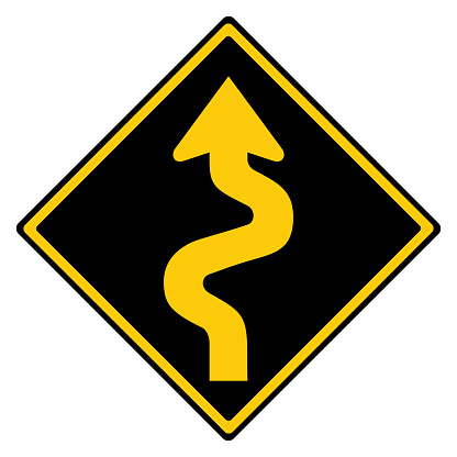 Yellow and black Australian winding road warning road sign in reverse colours, isolated on white background with clipping path
