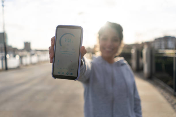 istock Happy woman using app to track her progress while running outdoors 1194895585