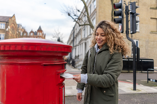Young woman sending a letter by mail in London â lifestyle concepts