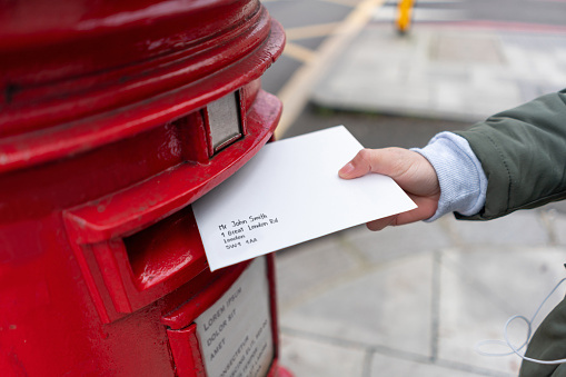 Close-up on a woman sending a letter by mail in London â lifestyle concepts