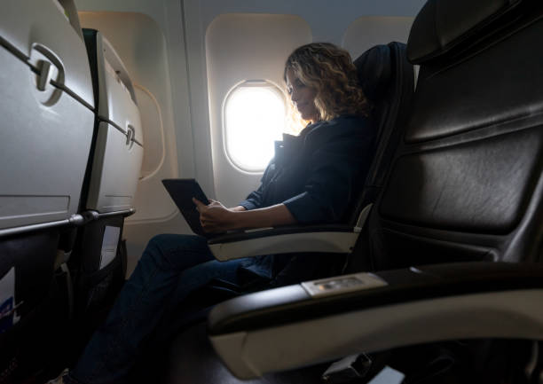 istock Pretty latin american woman using her tablet during a commercial flight 1194896972
