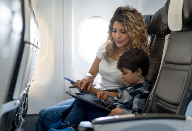 istock Young beautiful mother and her son playing together on tablet during a flight 1194896992