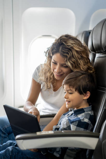 istock Beautiful young mother and son playing together on digital tablet during a flight 1194896994
