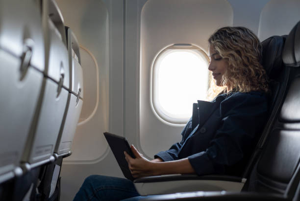 istock Young latin american woman during a flight having fun with tablet 1194897006