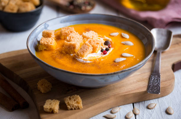 Delicious pumpkin soup in a bowl with croutons on white wood pumpkin soup with croutons on white wooden background pumpkin soup photos stock pictures, royalty-free photos & images