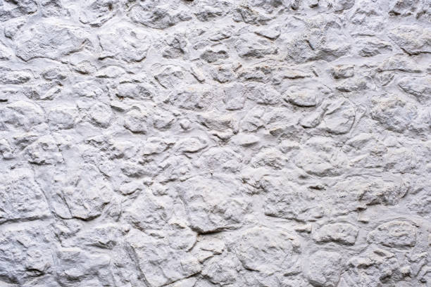 istock Whitewashed stone wall of small, medium and large stones. 1194899496