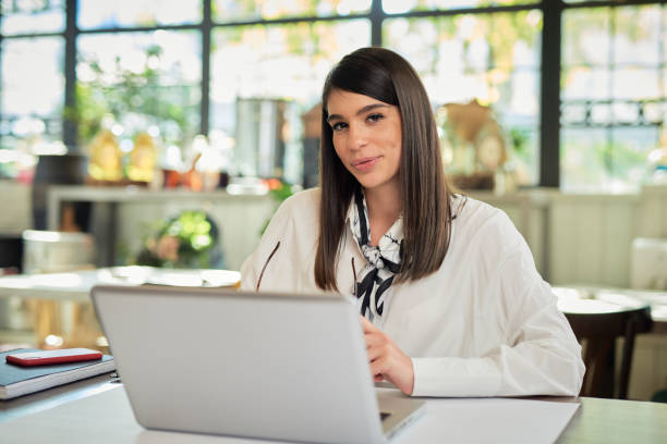 istock Attractive caucasian elegant brunette posing in cafe.  On table is laptop. 1194902473