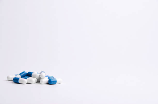 istock Blue and white pills on a light background with place for text. Biological supplements, vitamins, medicines for health. 1194906093