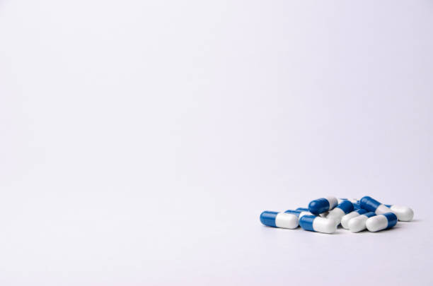 istock Blue and white pills on a light background with place for text. Biological supplements, vitamins, medicines for health. 1194906113