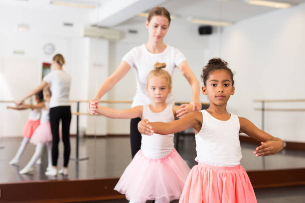 istock Dance teacher helping her little girls students 1194908062