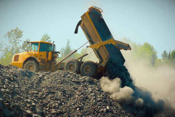 truck moving earth construction site machine industrial yellow equipment road construction site large yellow truck dumping rock dump truck photos stock pictures, royalty-free photos & images