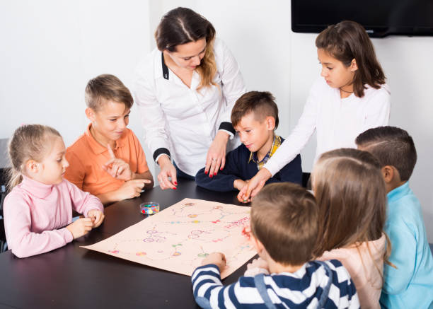 istock Happy kids thinking  at table with board game 1194910238