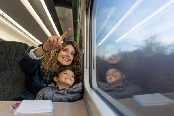 istock Loving mother and son pointing at the window view while traveling by plane both smiling 1194911026