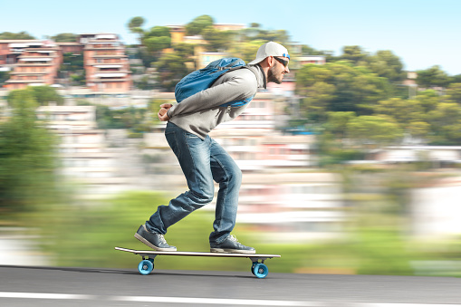 A man rides on a skateboard on the highway. Side view