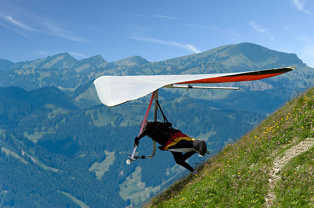 Man jumping from a hill with hang-glider