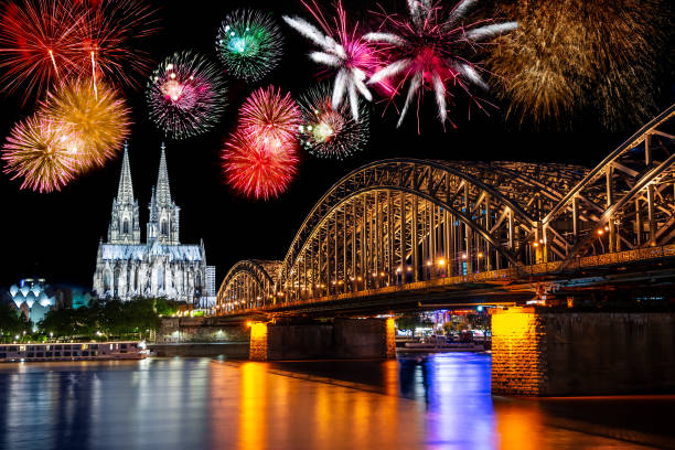 Night with fireworks in Cologne at the river Rhine with the illuminated cathedral and the Hohenzollern Bridge.