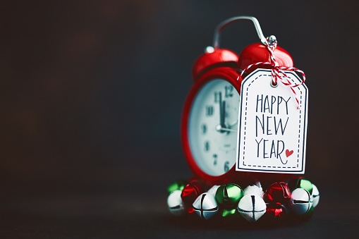 Alarm clock with Happy New Year Message and holiday decorations. New Year 2020