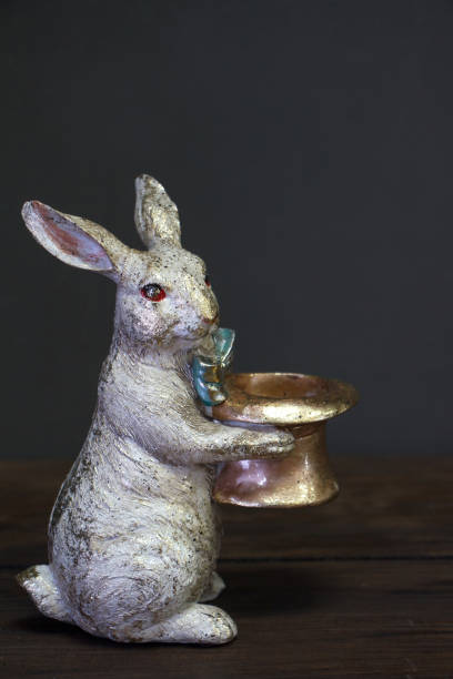 istock Close-up of a white-golden statuette of an Easter bunny holding a empty hat, Easter background or concept, selective focus 1194917810