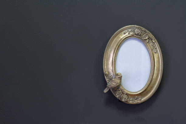 istock Empty gold vintage oval frame in Victorian style on a gray wall, background or concept 1194917825