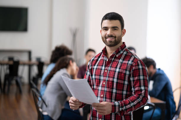 istock Young business man at a coworking office holding documents smiling at camera 1194917991