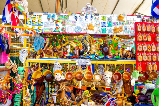 lembranças étnicas, bonés de beisebol, bolsas com vários padrões pendurados no mercado de rua - baseball cap hat merchandise nature - fotografias e filmes do acervo