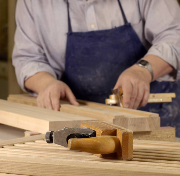 istock Man with blue apron working with wood 119491868
