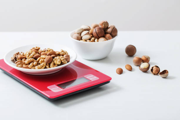 istock mix of different nuts on  kitchen scale on a white table 1194921627