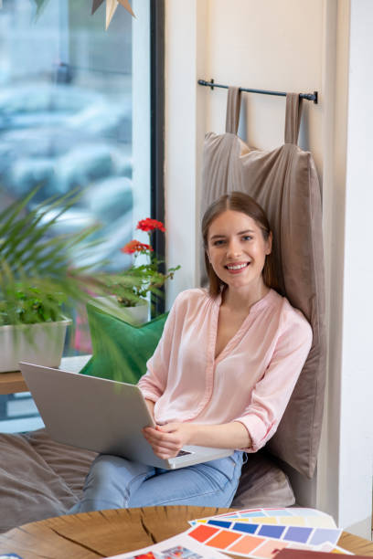 istock Smiling young designer working with her laptop 1194922841