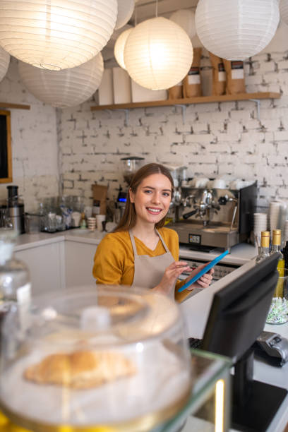 istock Cheerful cafe employee taking orders online via tablet 1194922871