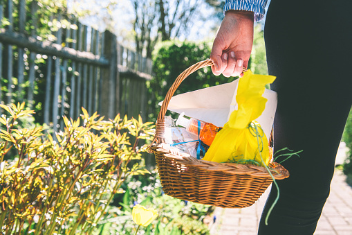 teenage girl girl holding basket with easter gifts in subby garden