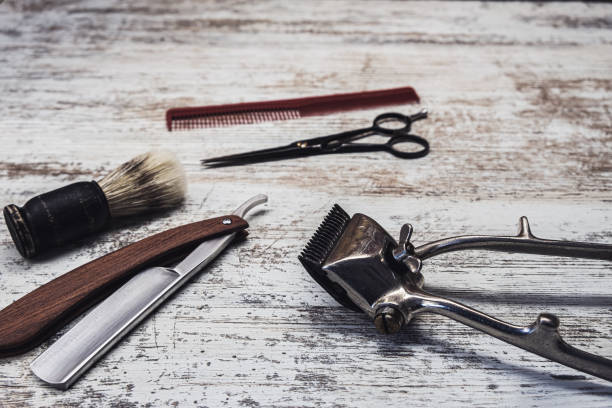 istock vintage barber tools dangerous razor hairdressing scissors old manual clipper comb shaving brush. old white weathered wood background. 1194924480
