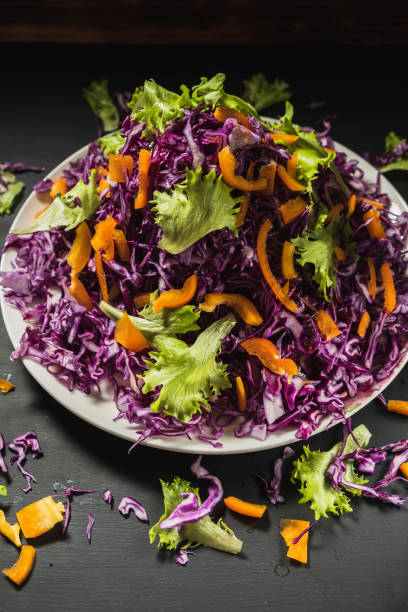 istock head lettuce bell pepper red cabbage salad casually scattered around a flat dish. vertical. 1194925127