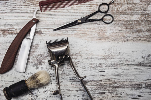 istock vintage barber tools dangerous razor hairdressing scissors old manual clipper comb shaving brush. old white weathered wood background. 1194925318