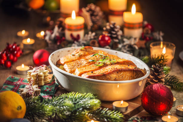 cena de navidad de salmón de pescado en plato asado con corona de adviento de decoración festiva y velas. - baked salmon fotografías e imágenes de stock
