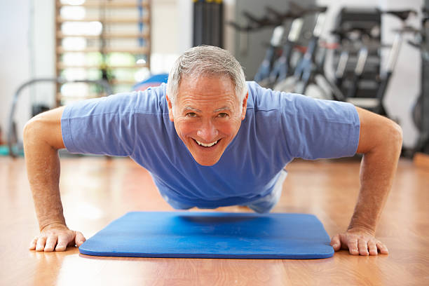 homem sênior dando pressione ups na academia de ginástica - sit ups - fotografias e filmes do acervo