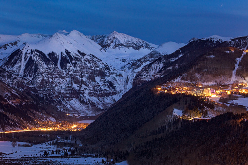 Telluride, Colorado and Mountain Village glow beneath the San Juan Mountains on a cold, winter night.