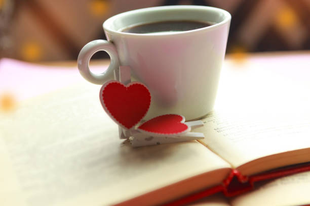 istock Coffee cup and decorative hearts on old books. Valentine's Day concept 1194934345