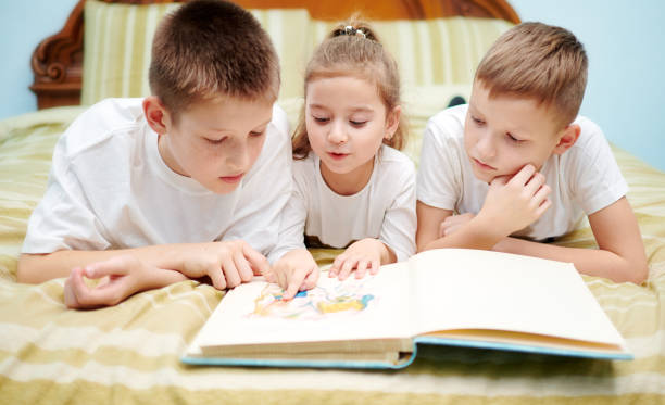istock Three children are looking into a book only 1194939247