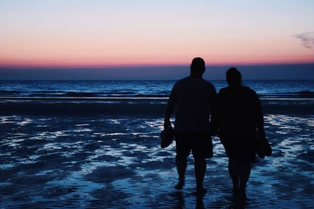 istock a couple strolling at the beach 1194943521