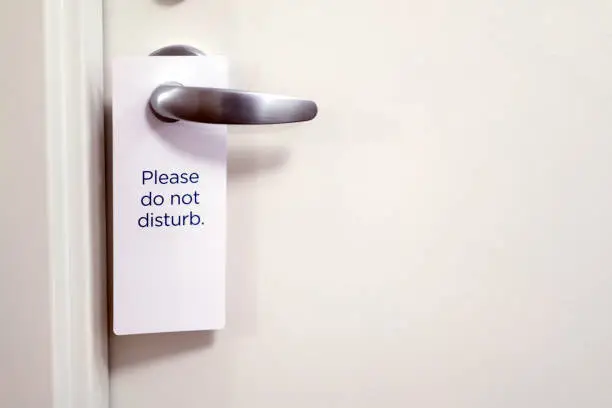Photo of Closed door of hotel room with please do not disturb sign