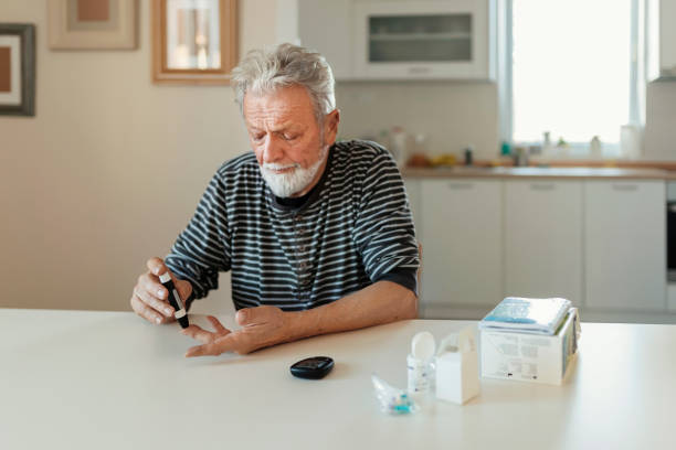 homme aîné avec le glucomètre - blood sugar test examining instrument of measurement diabetes photos et images de collection